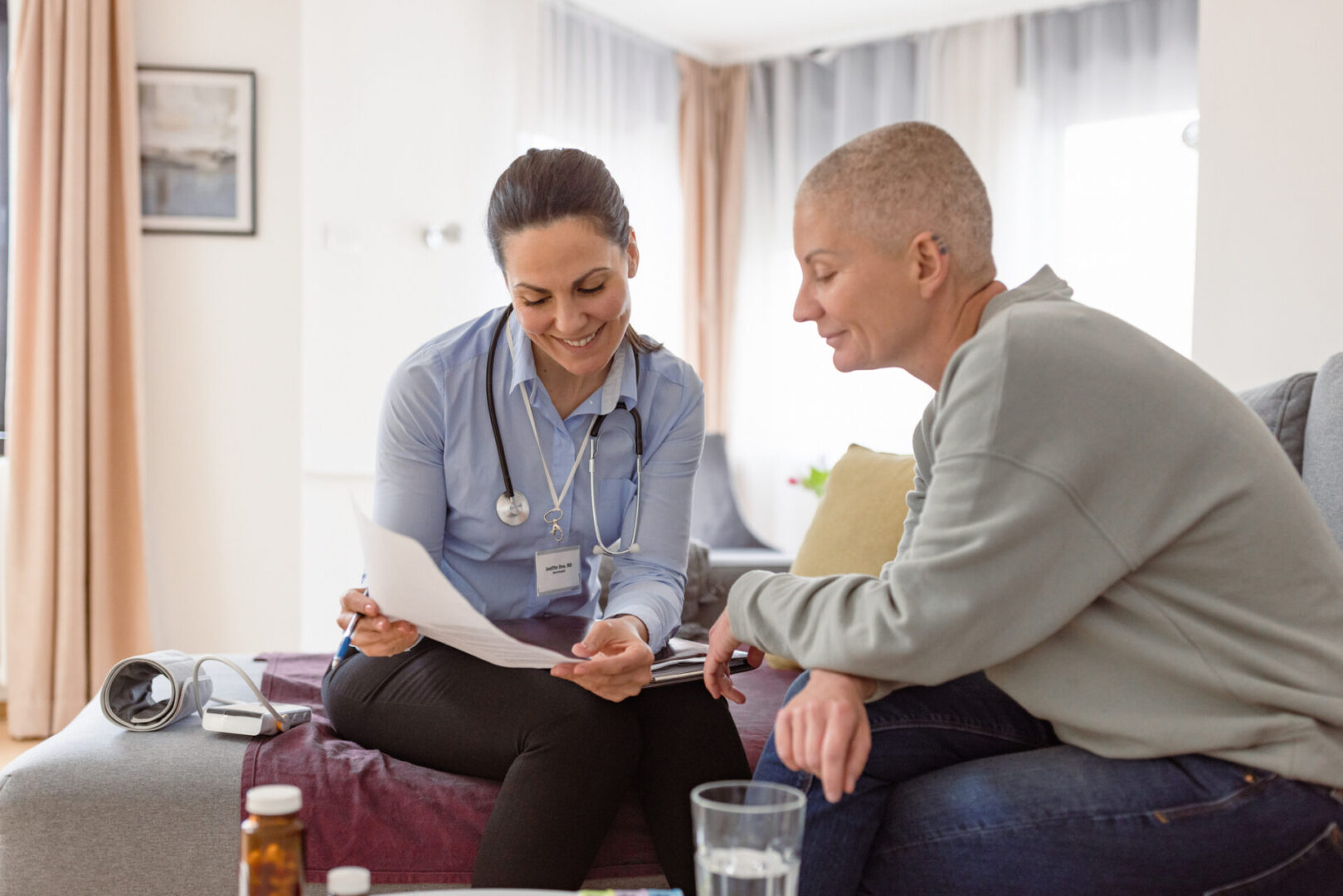 Doctor discussing paperwork with patient at home.